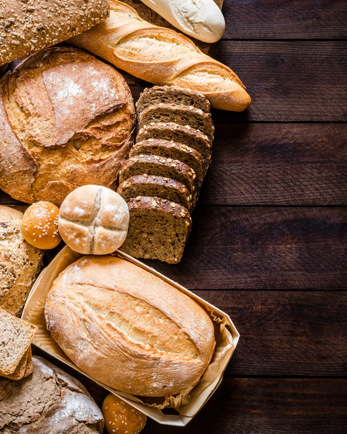 Assortment of breads and rolls on a dark wooden table