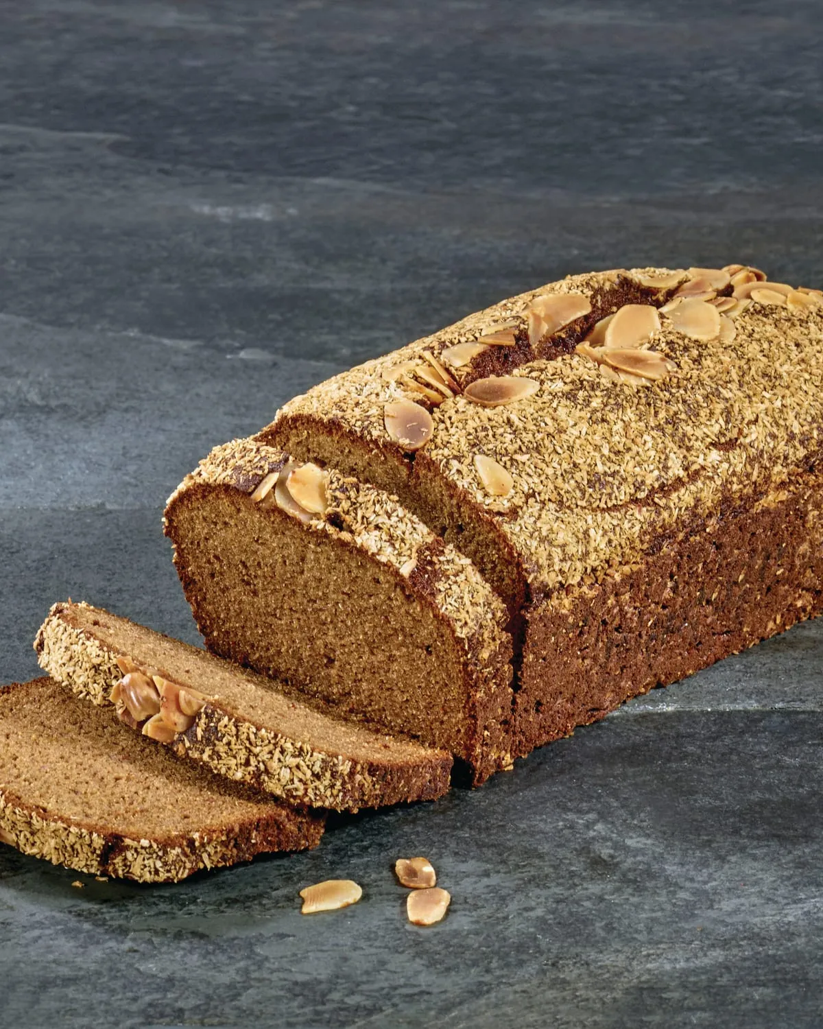 Sliced chia loaf cake on a dark surface