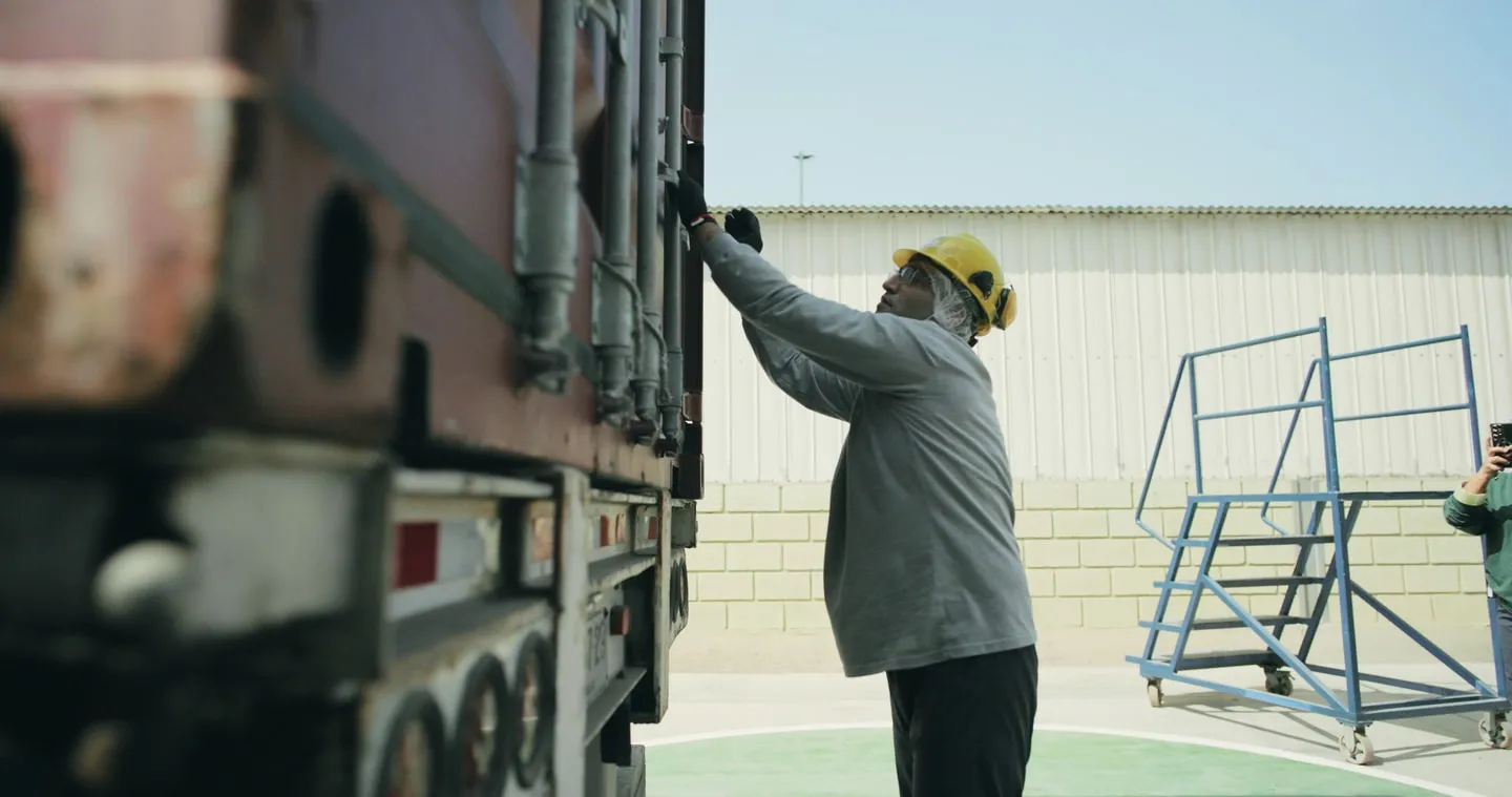 A worker loading a shipping container at the plant
