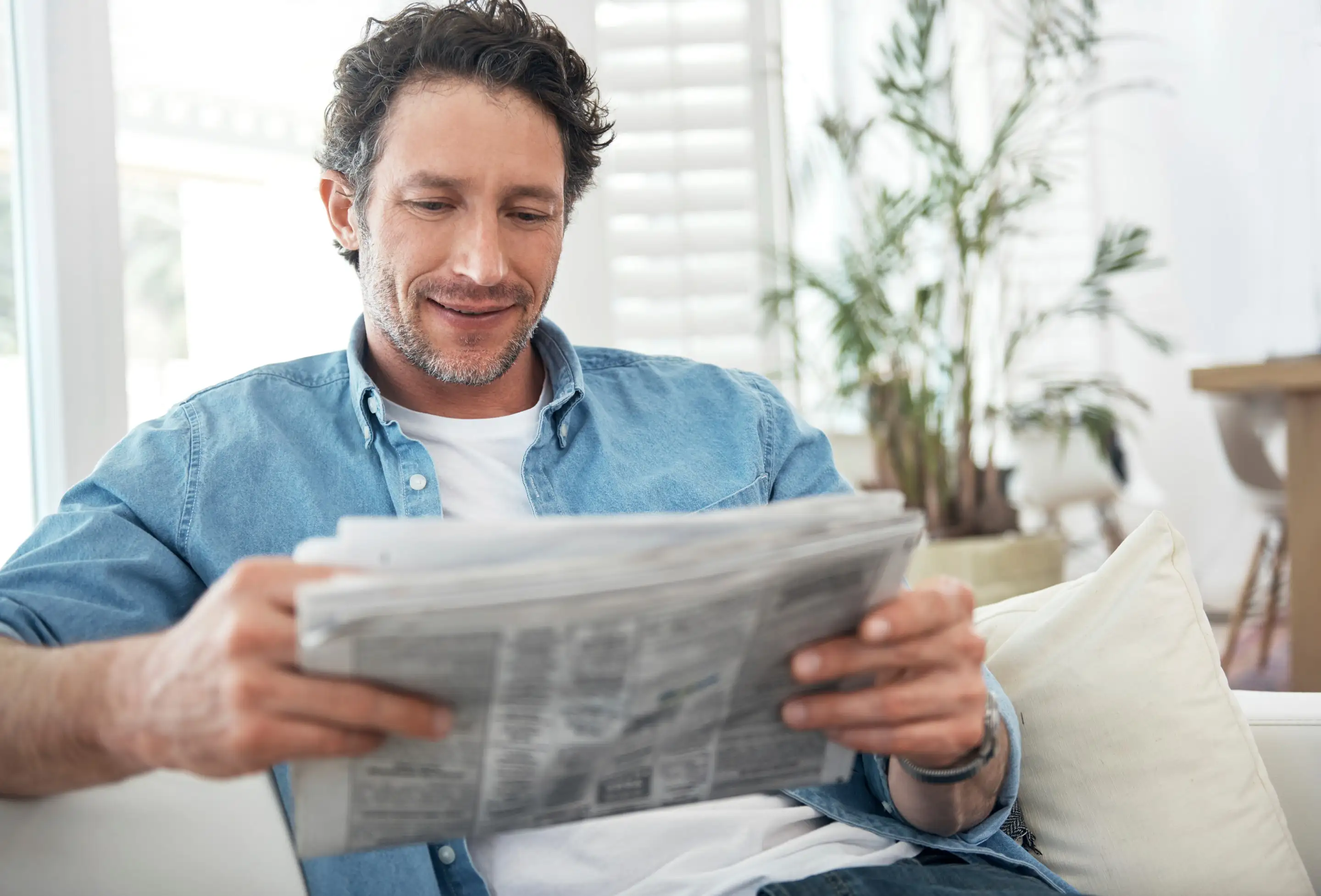 A man reading a newspaper at home