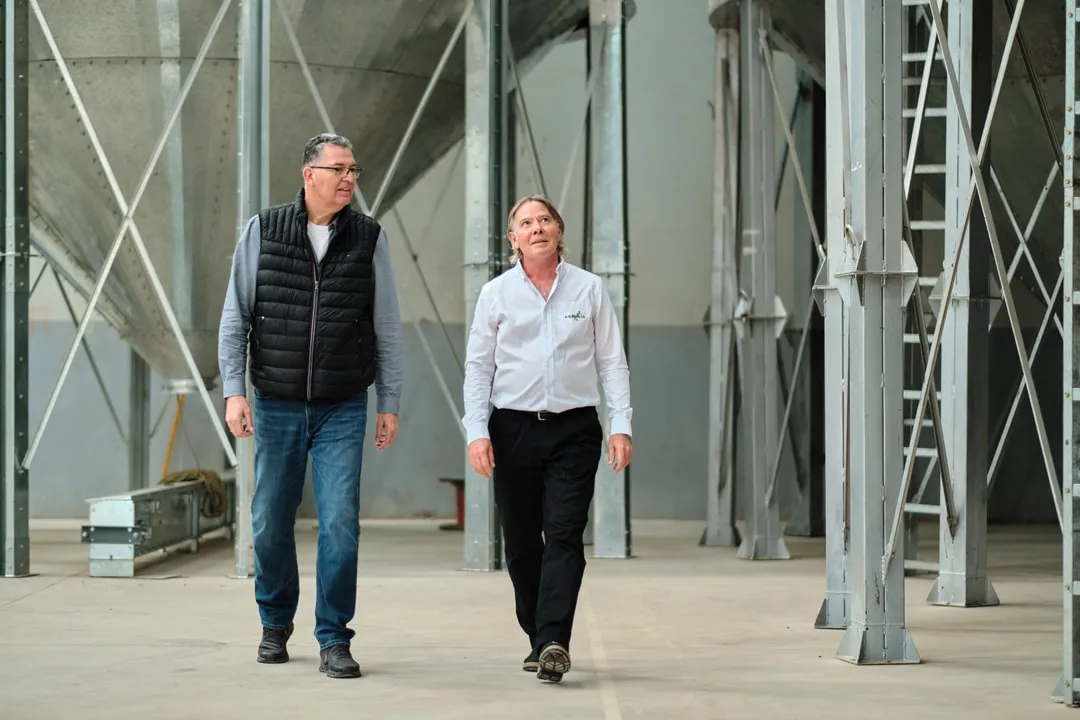 Two colleagues walking between the seed silos